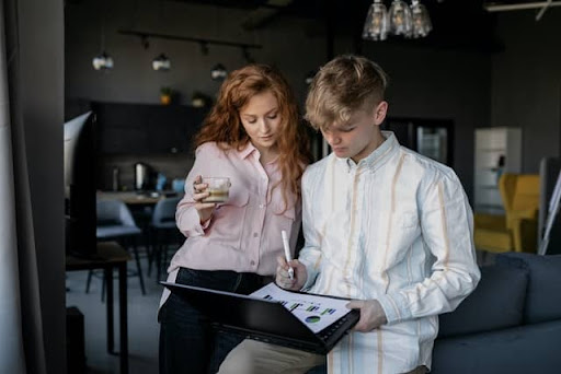 Two employees look over a chart