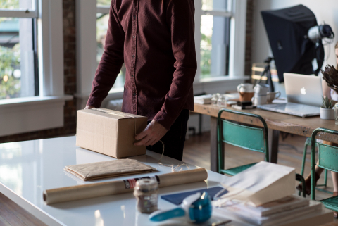 Small business owner preparing package for shipping.