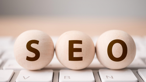 SEO written on wooden balls sitting on a keyboard.