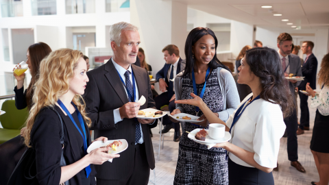 group of people talking at a breakfast event at work.