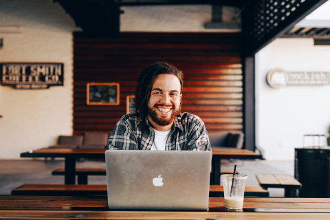 Man sitting at computer inside a store.