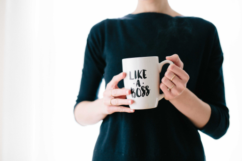 Woman holding a coffee cup that says 