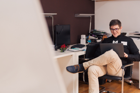 Young man working on a laptop in an office.