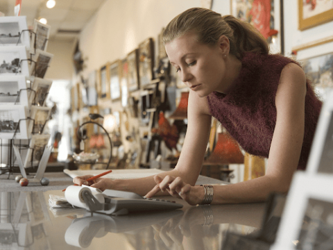 Worker in an art framing shop using a calculator.